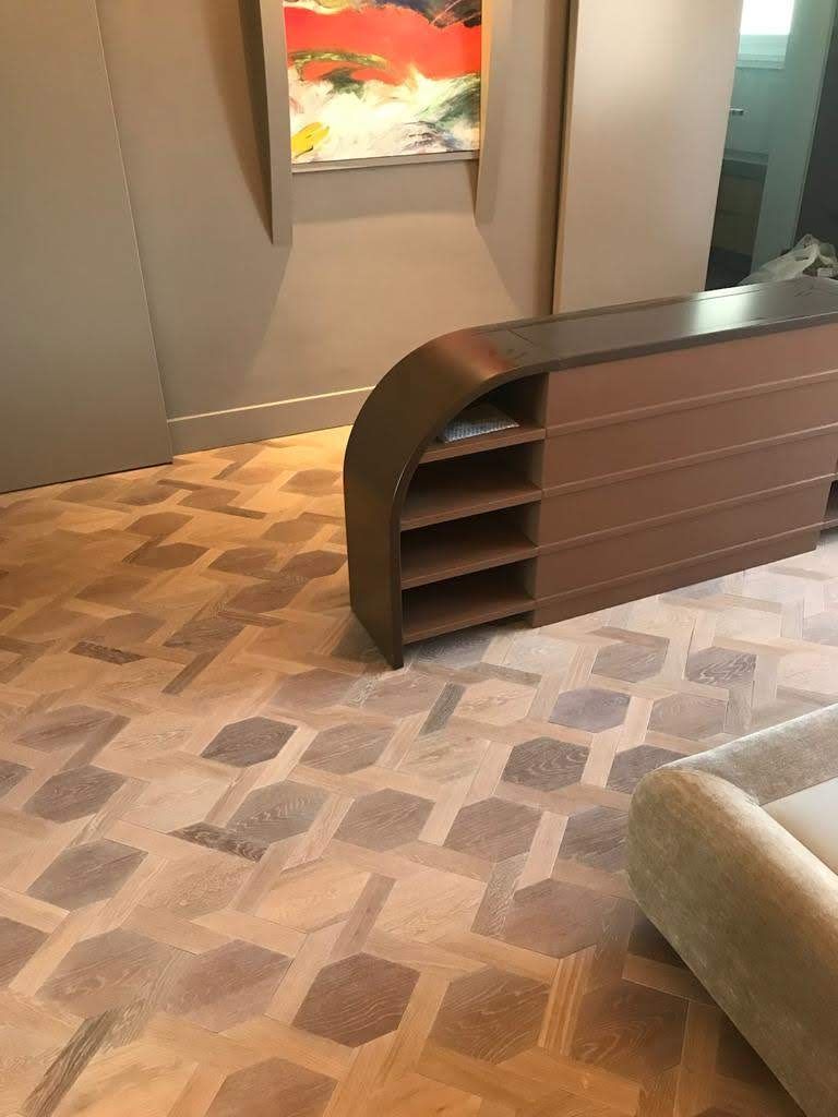 Moderna hall d'ingresso per uffici con bancone reception curvo, moquette a motivi geometrici e opere d'arte alle pareti.