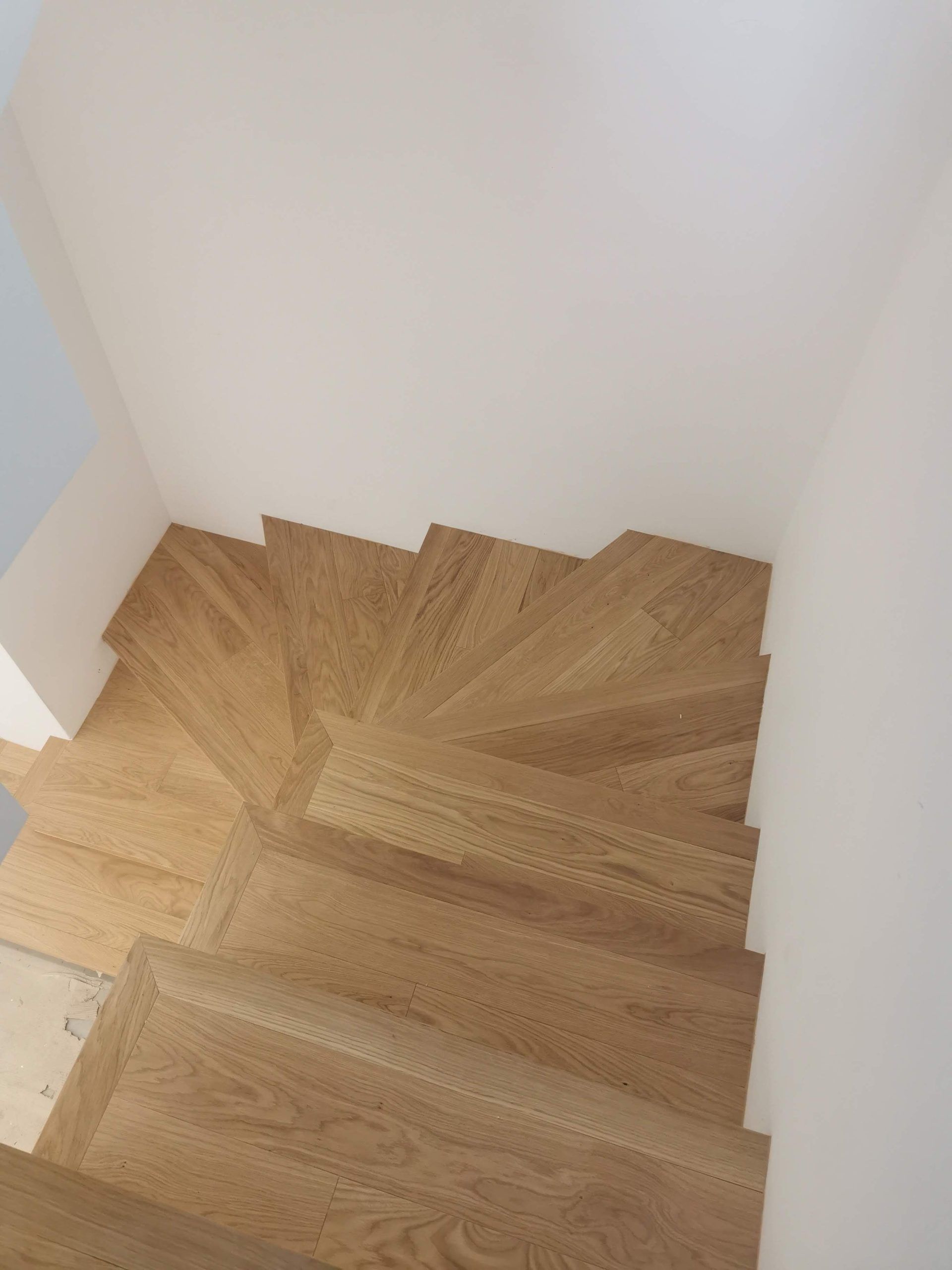 Scala a chiocciola in legno in un angolo interno bianco
