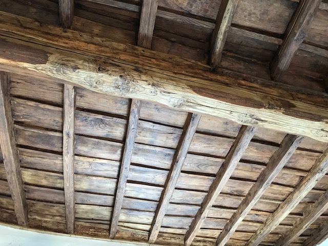 Travi e assi di legno a soffitto all'interno di una struttura rustica