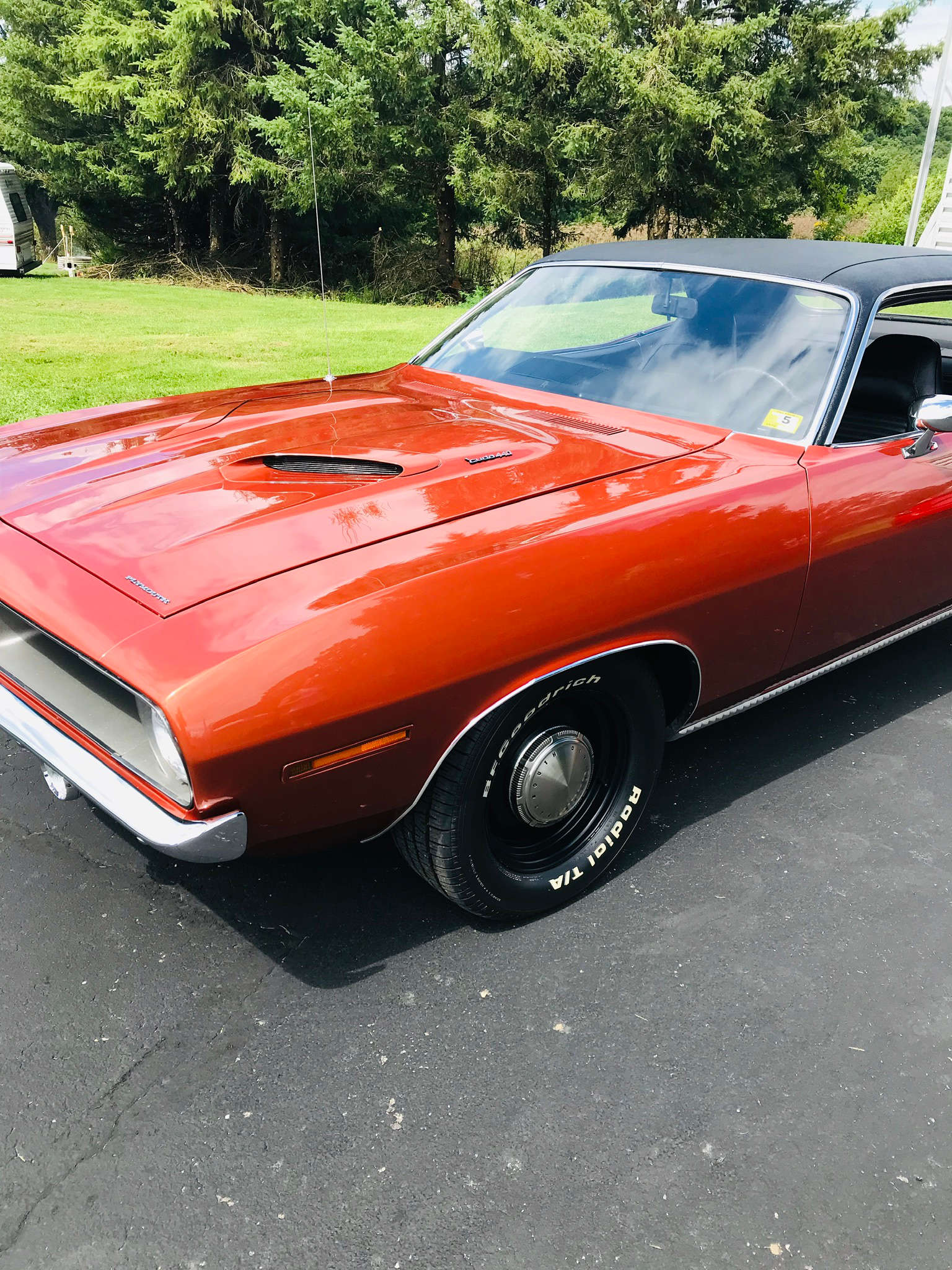 A red dodge challenger is parked on the side of the road.