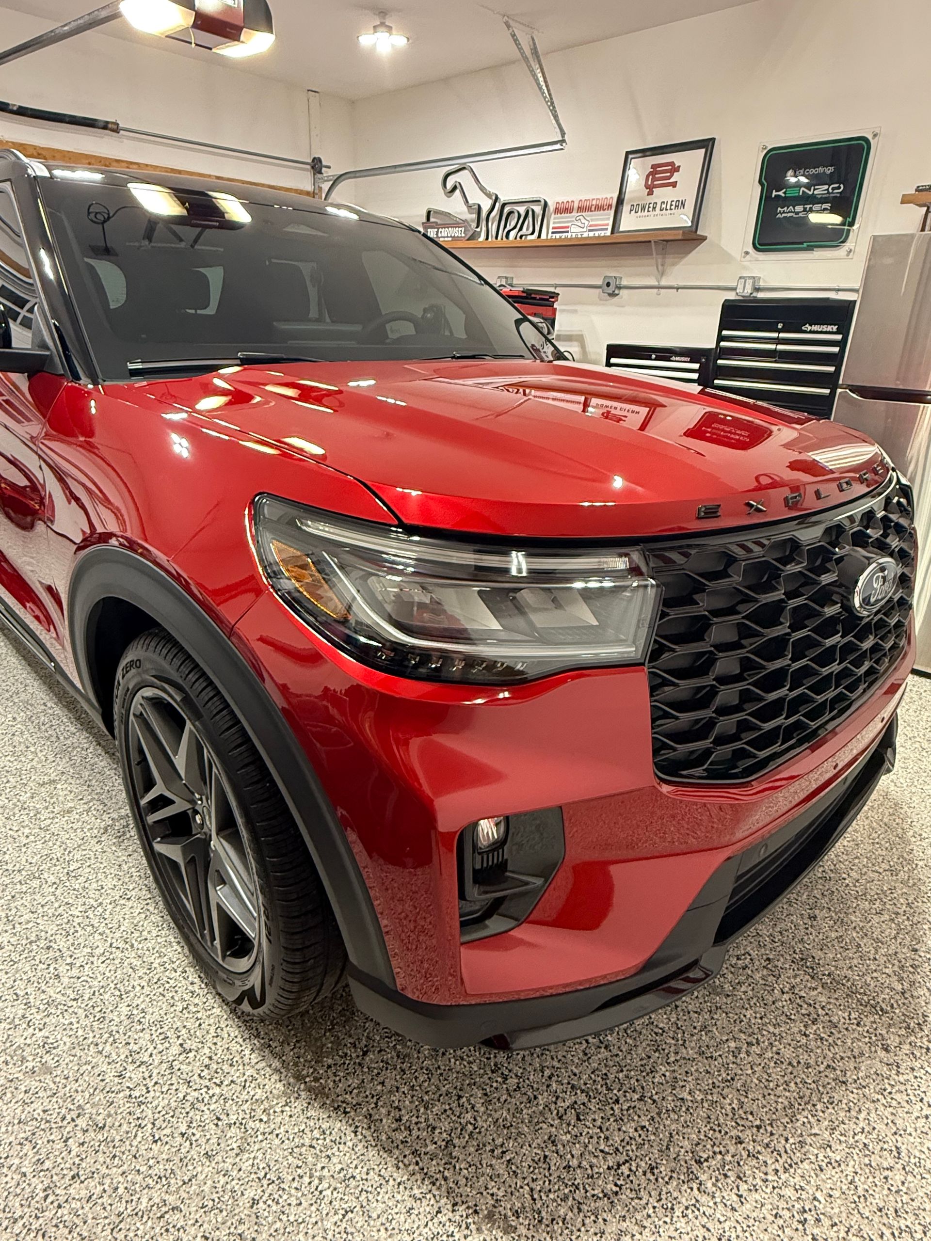 A red ford explorer is parked in a garage.