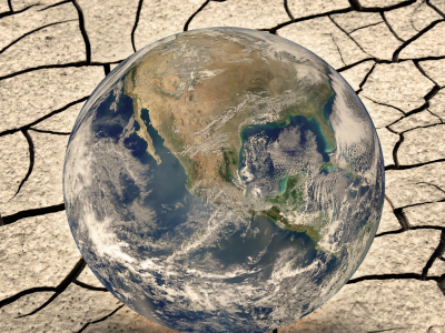 A globe is sitting on top of a cracked ground.