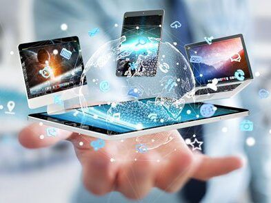 A person is holding a tablet and a laptop in their hand.