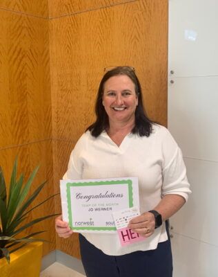 A woman is holding a sign that says congratulations on it.