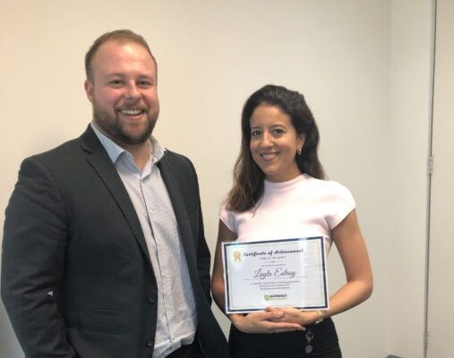 A man and a woman are standing next to each other holding a certificate.