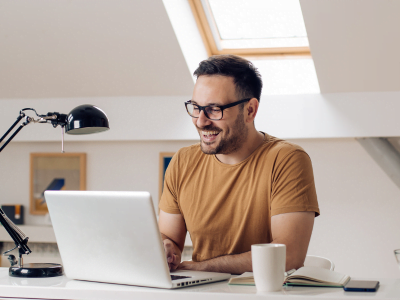 A man is sitting at a desk using a laptop computer.