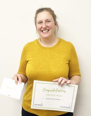 A woman in a yellow shirt is holding a certificate and smiling.