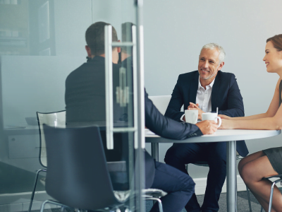 A group of people are sitting at a table having a meeting.