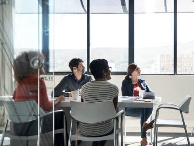 A group of people are sitting around a table in a conference room.