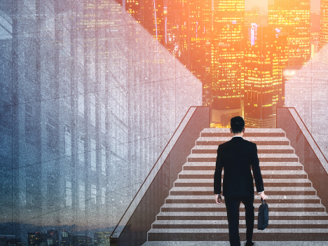 A man in a suit is walking up a set of stairs with a briefcase.