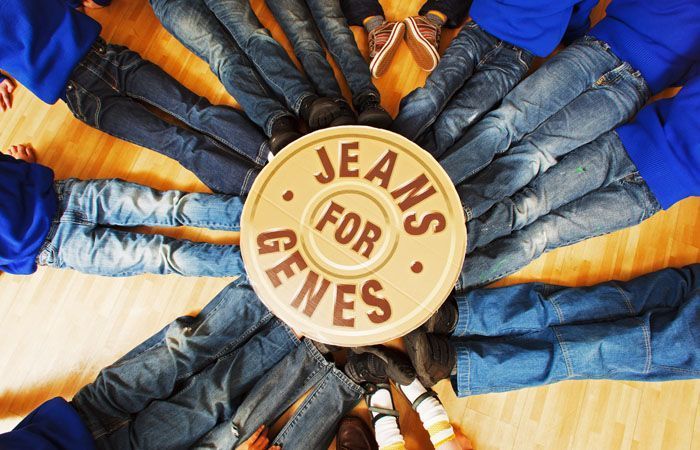 Jeans arranged in a circle around a center sign reading โJEANS FOR GENESโ