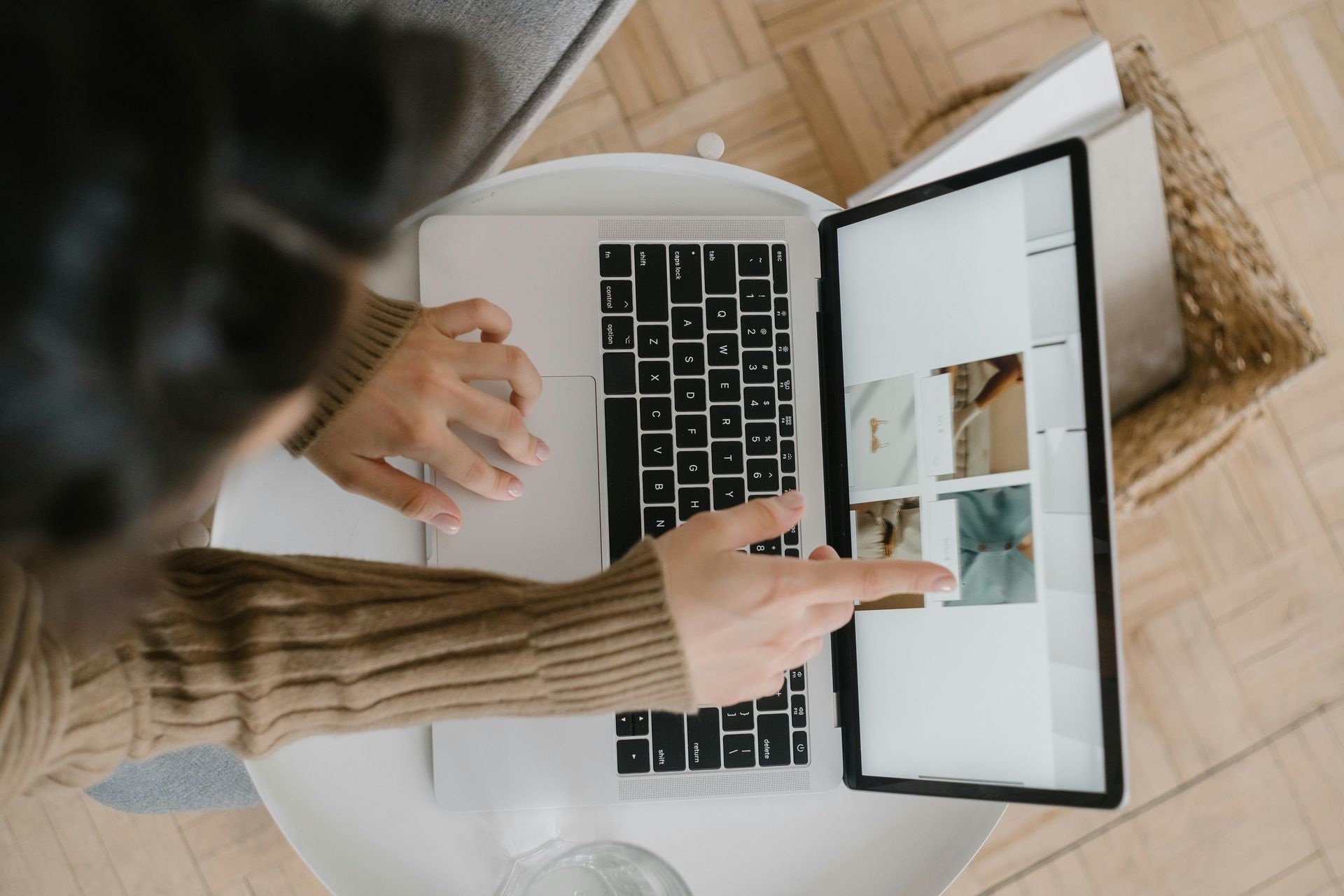 Person using a laptop with a split-screen website and touchpad, viewed from above