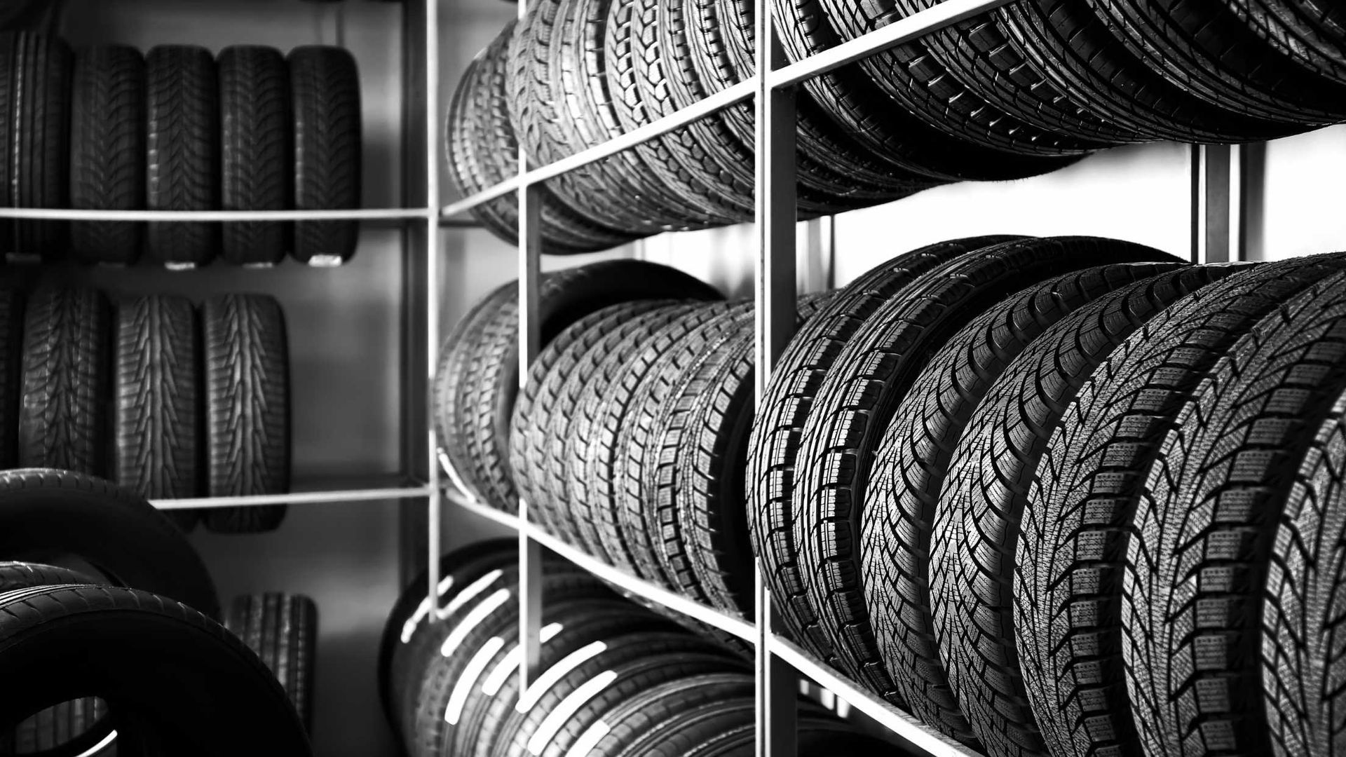 A black and white photo of a car tire on the ground.