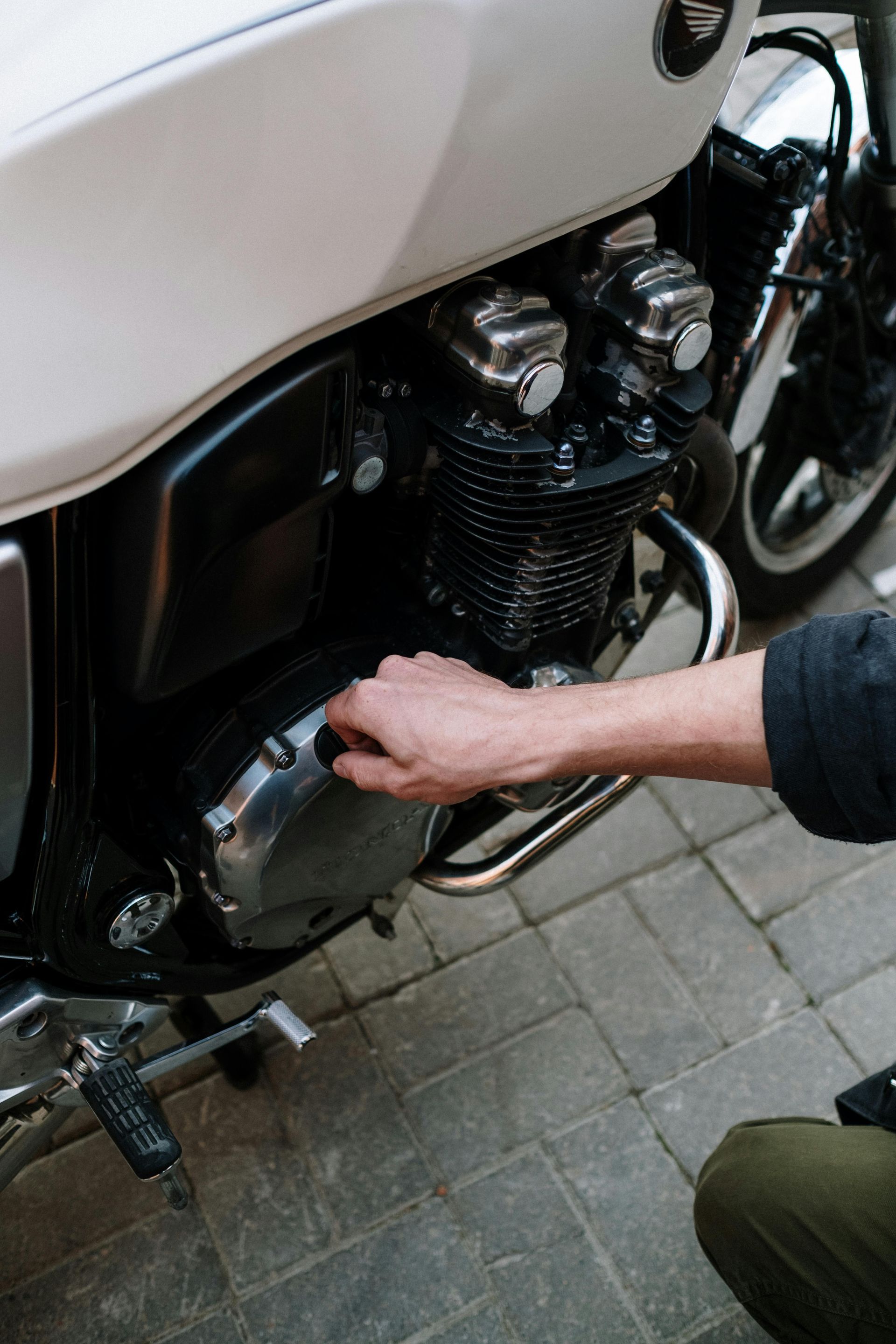 A man is working on the engine of a motorcycle.