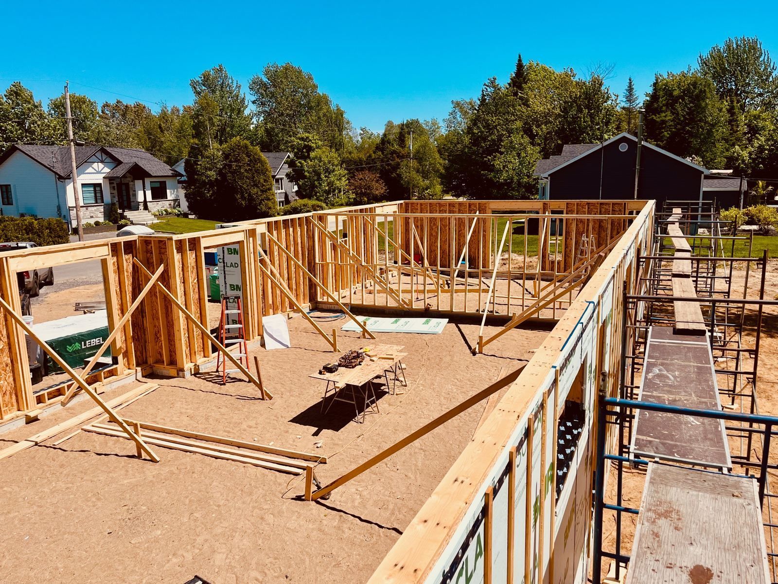 Vue d'ensemble du chantier avec murs intérieurs et échafaudages