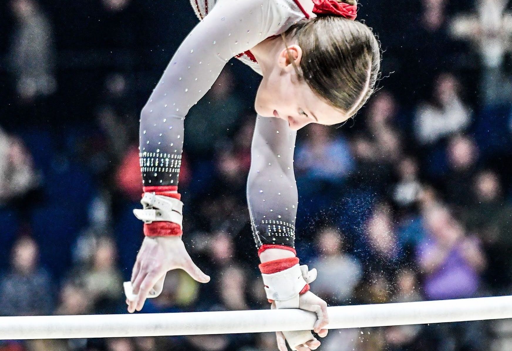 A female gymnast is doing a handstand on parallel bars