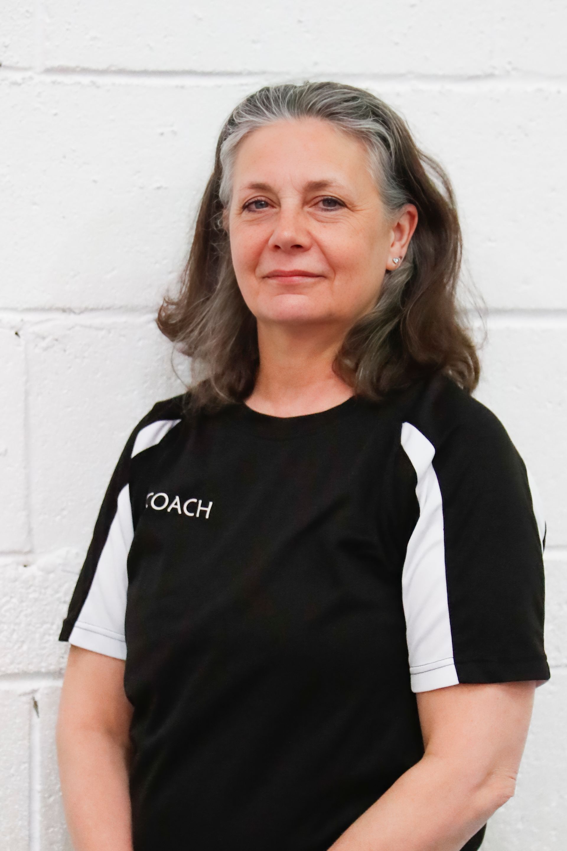 A woman wearing a black shirt that says coach on it