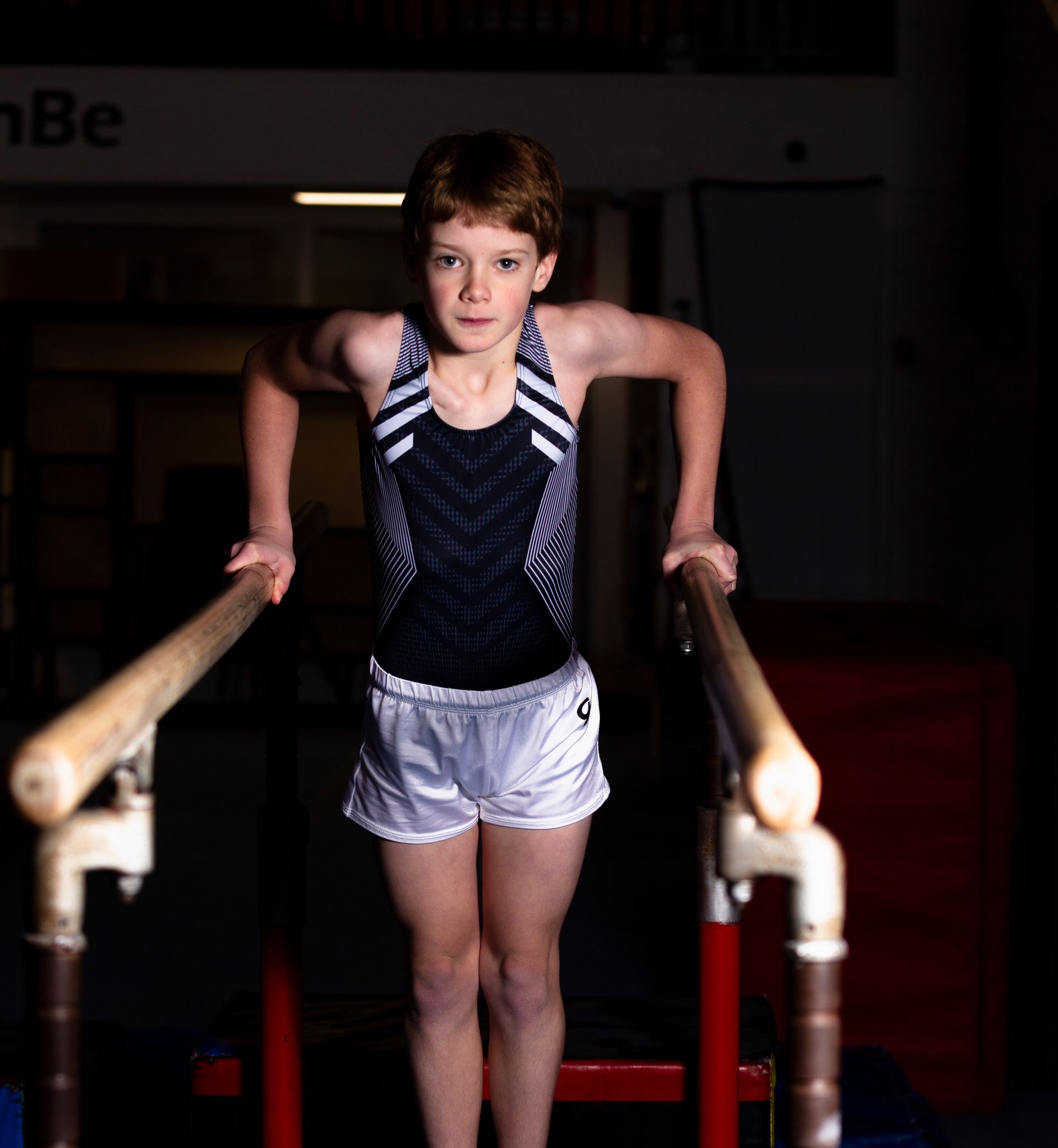 A female gymnast is balancing on a balance beam.