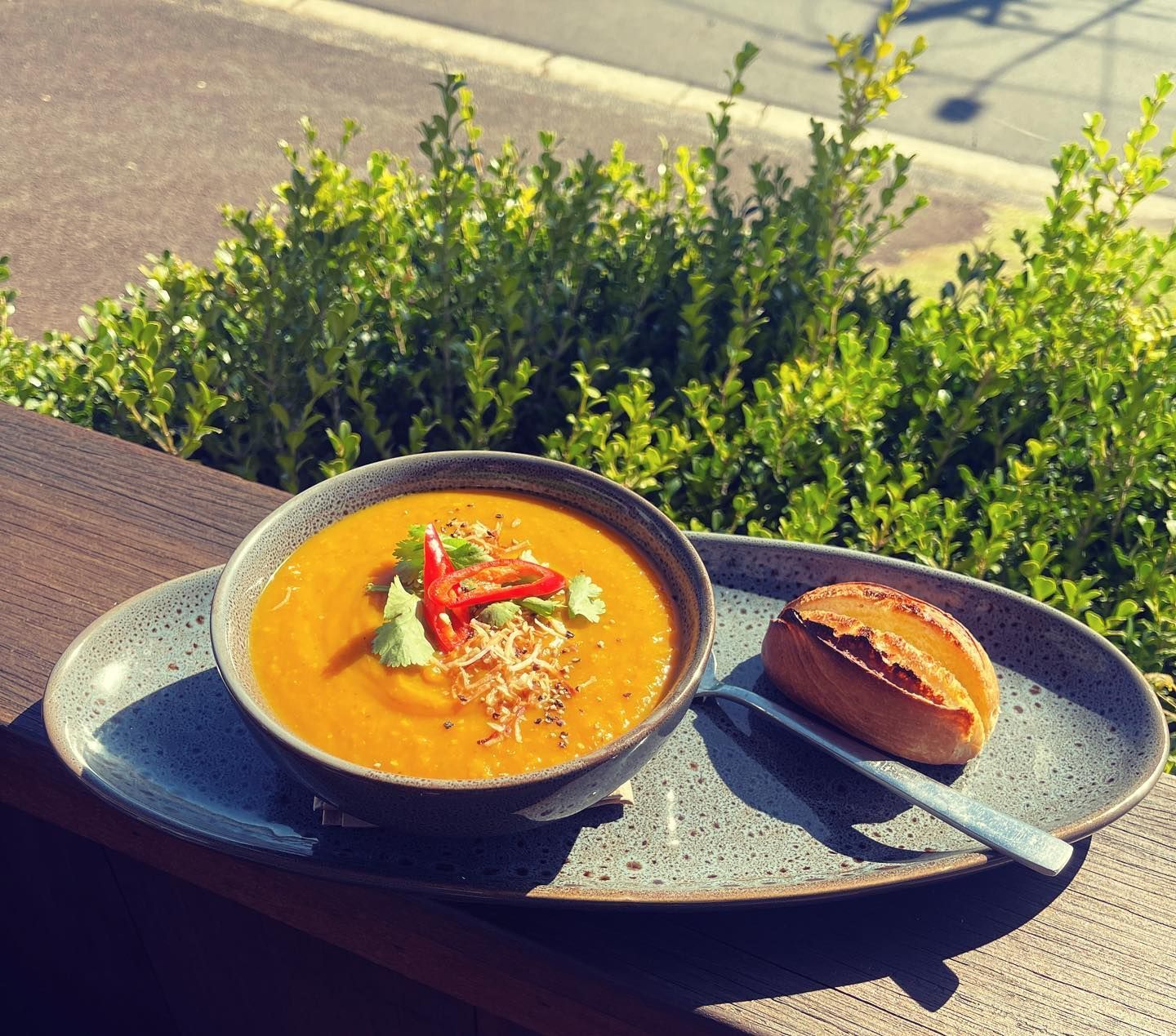 A bowl of soup and a loaf of bread on a plate