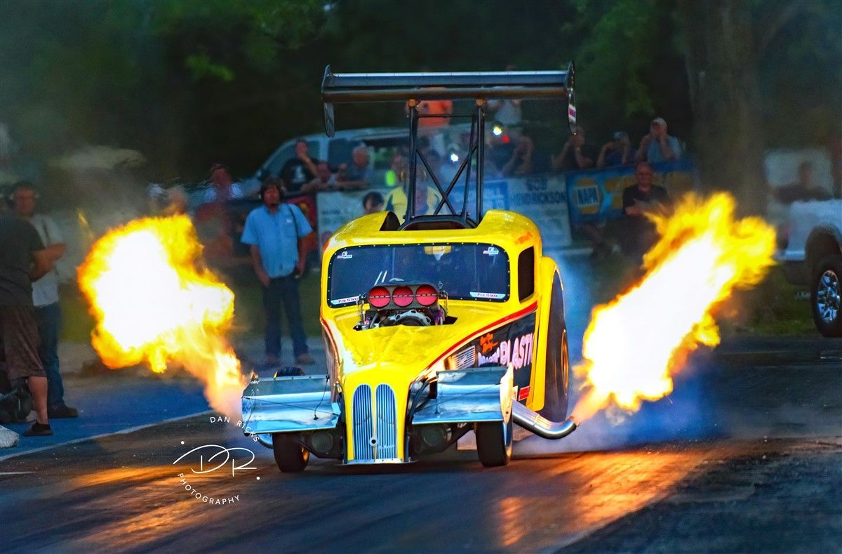 Yellow drag racing truck shooting flames.