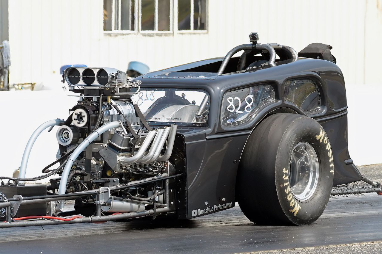 A black race car with the number 828 on the side is parked on the side of the road.