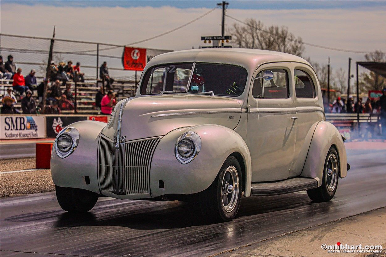 A white car is driving down a race track.