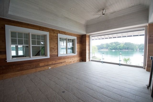 Indoor lakeside porch with wooden siding and large windows.