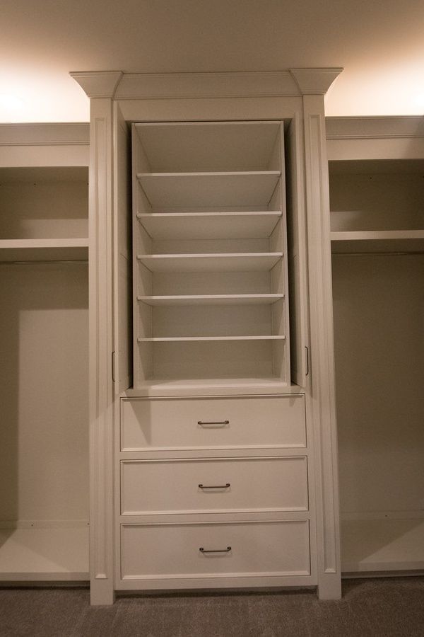 White closet with center shelves and drawers. Two side sections for hanging clothes.
