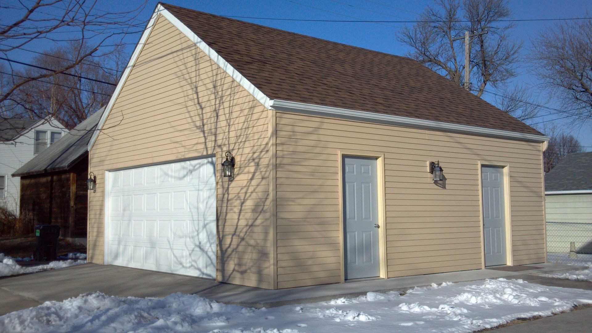 A garage with two doors and a brown roof