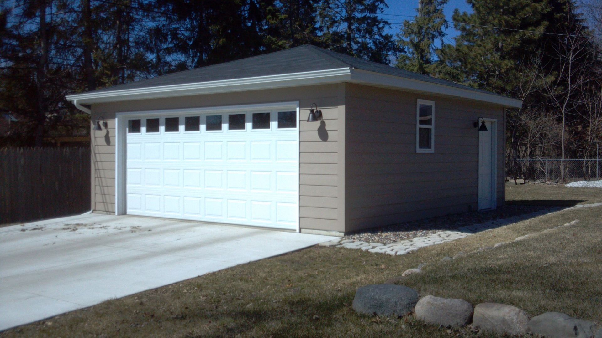 A garage with a white door and a concrete driveway