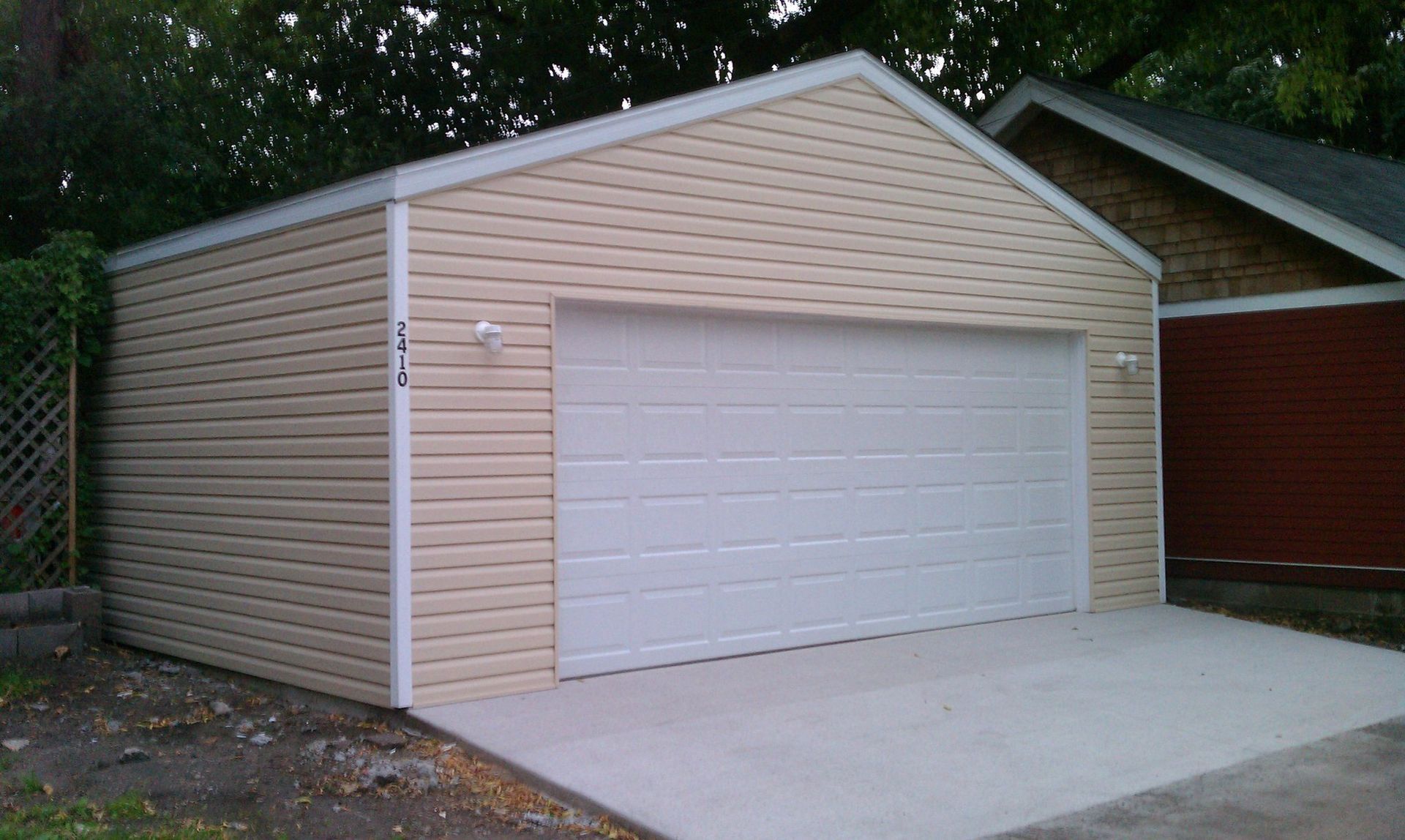 A garage with a white door is next to a house