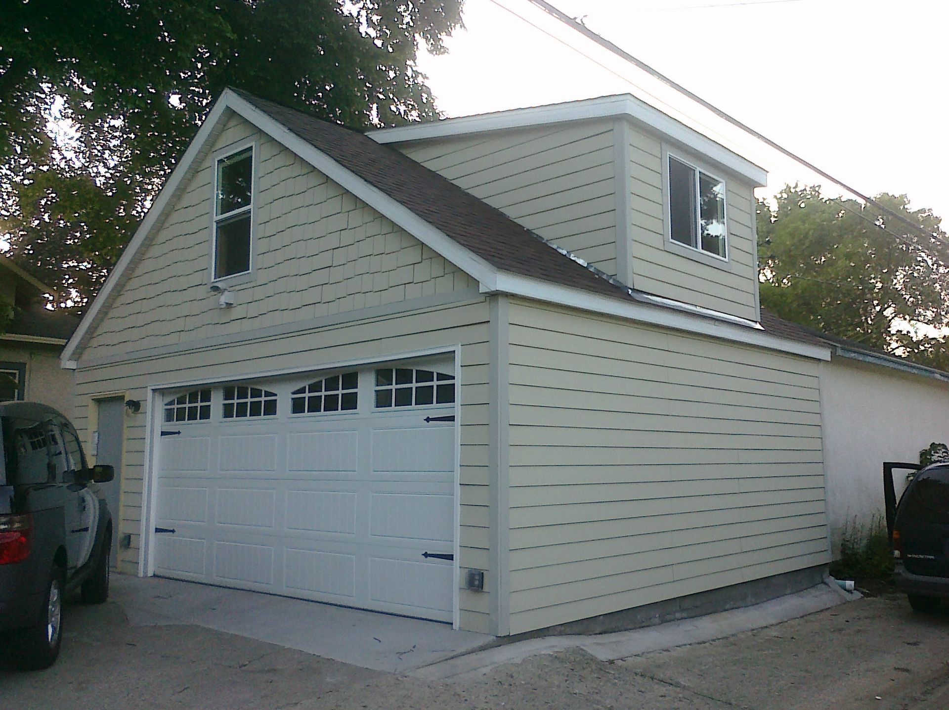 A white garage with a car parked in front of it
