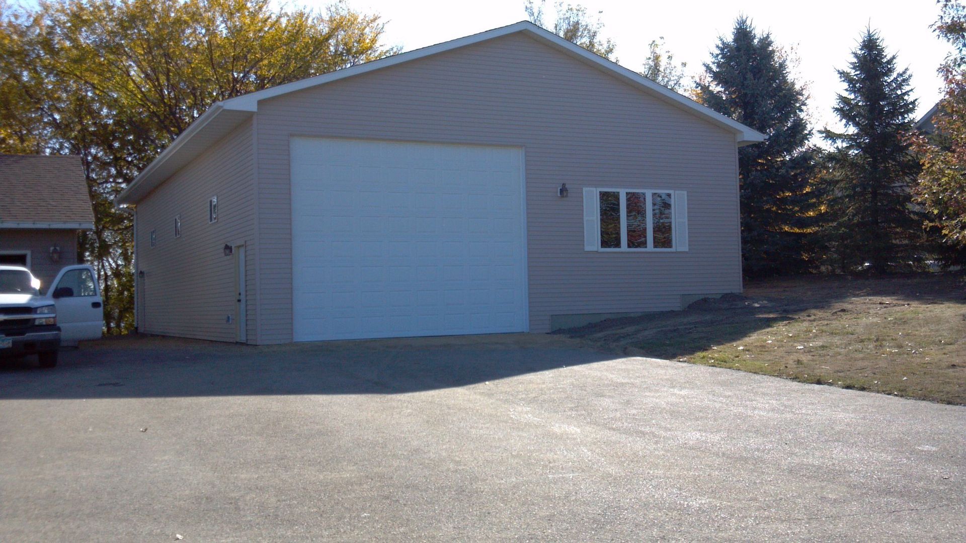 A garage with a white truck parked in front of it