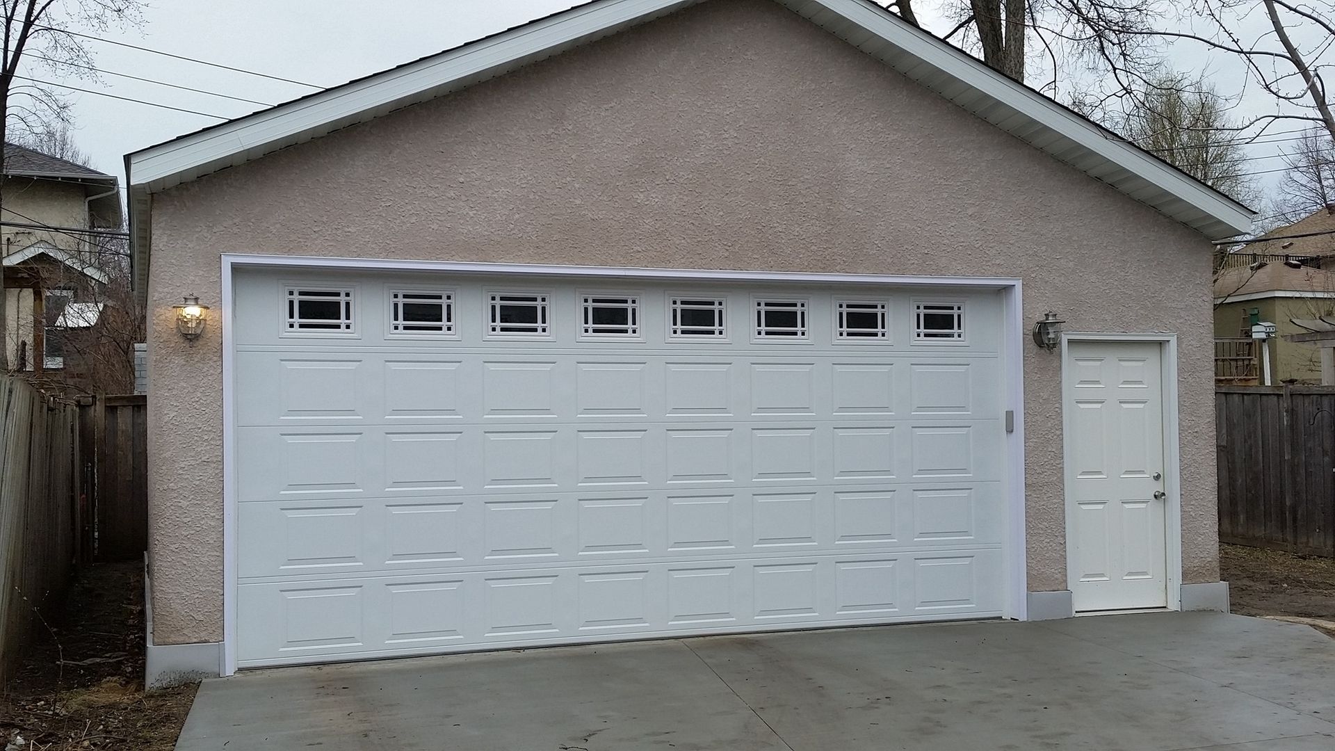 A garage with a white garage door and a white door