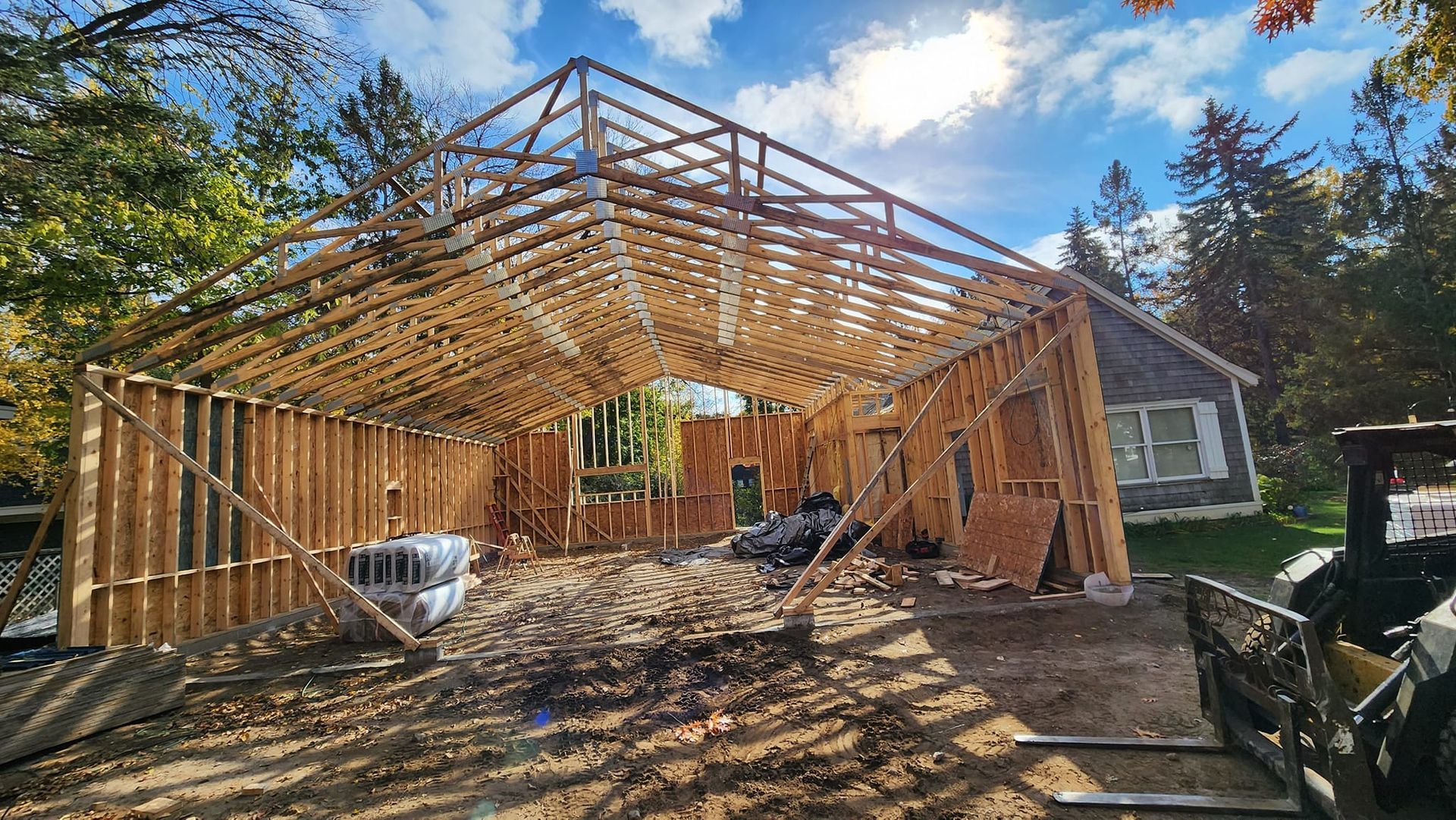 A large wooden structure is being built in front of a house.