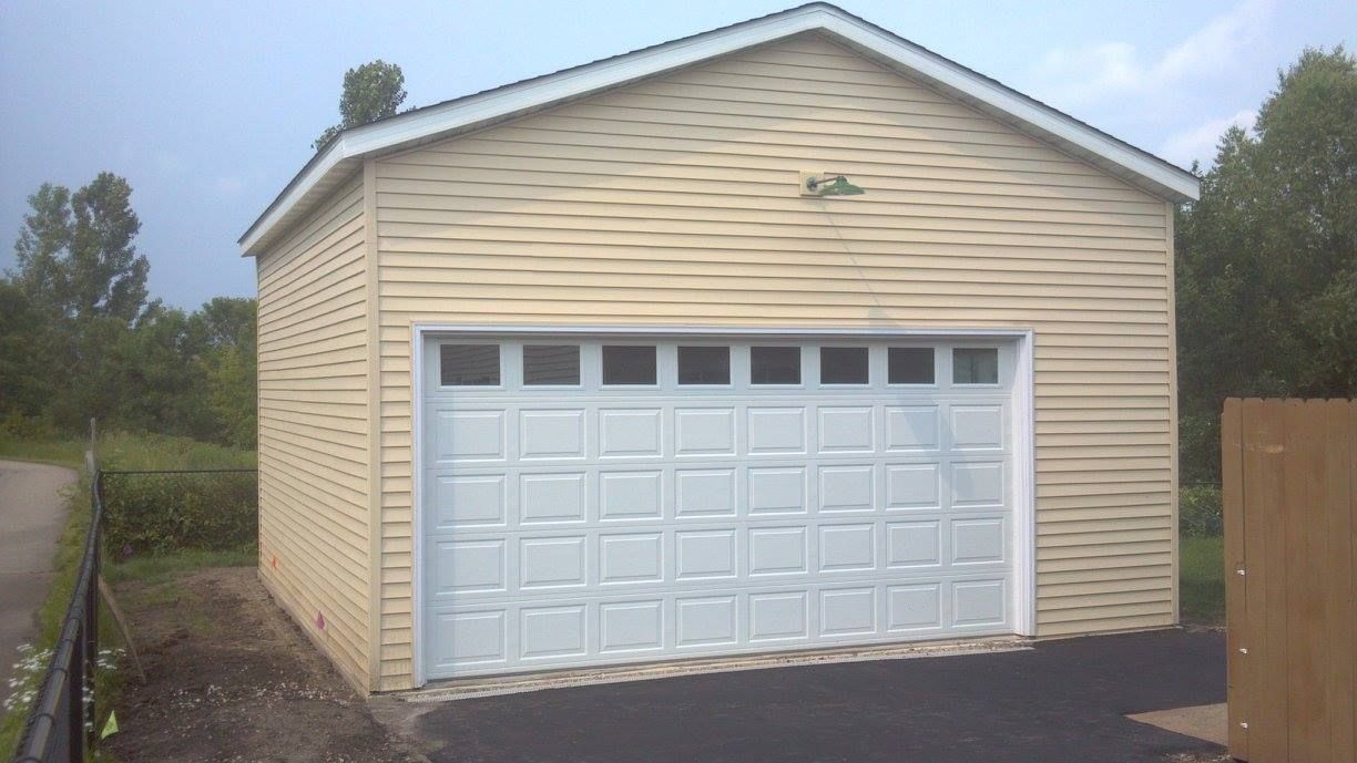 A garage with a white door and a wooden fence in front of it