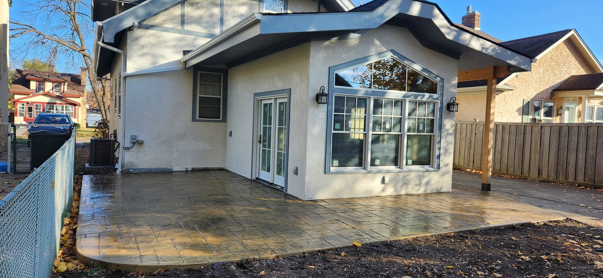 A white house with a large patio in front of it.