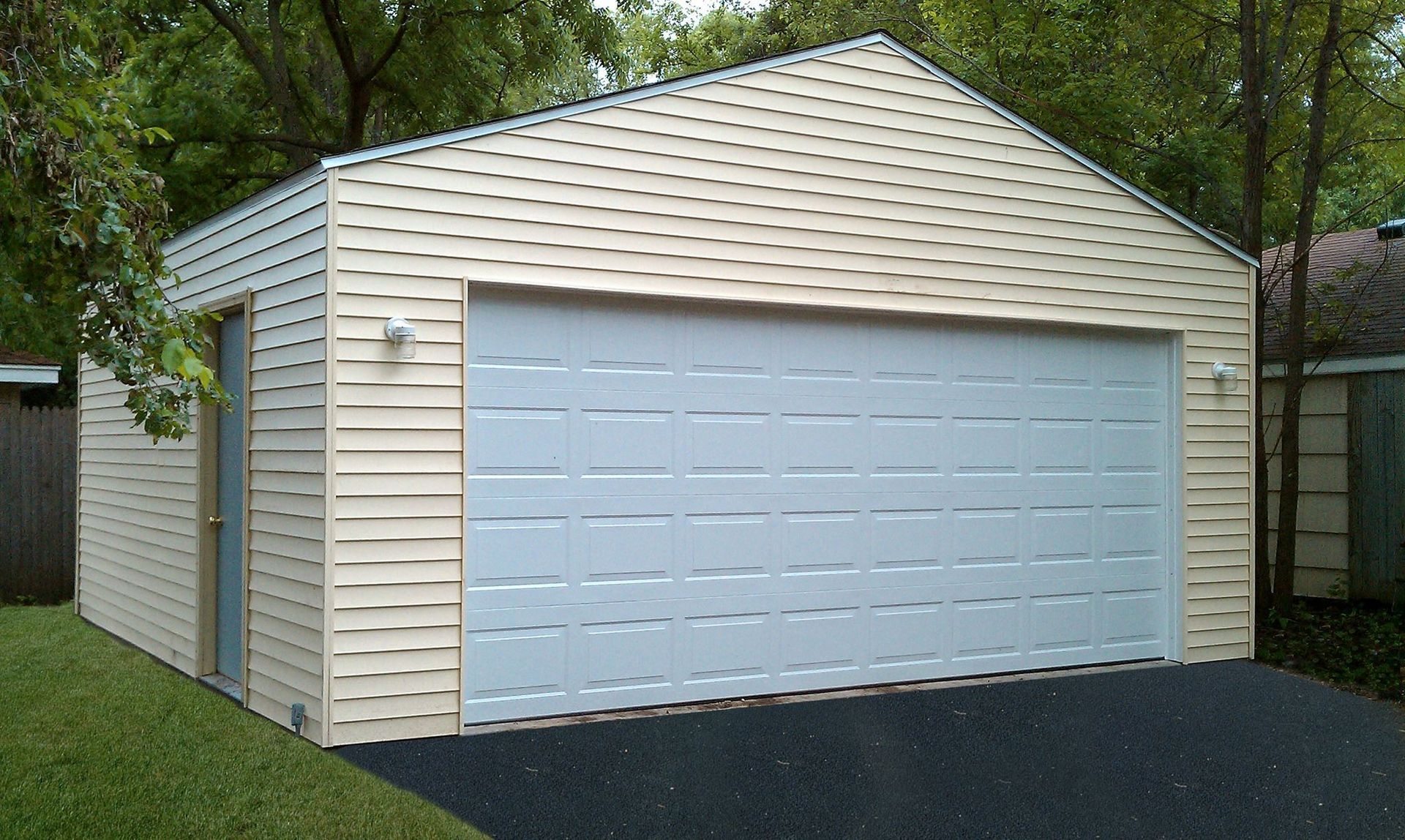 A white garage with a white door and a black driveway