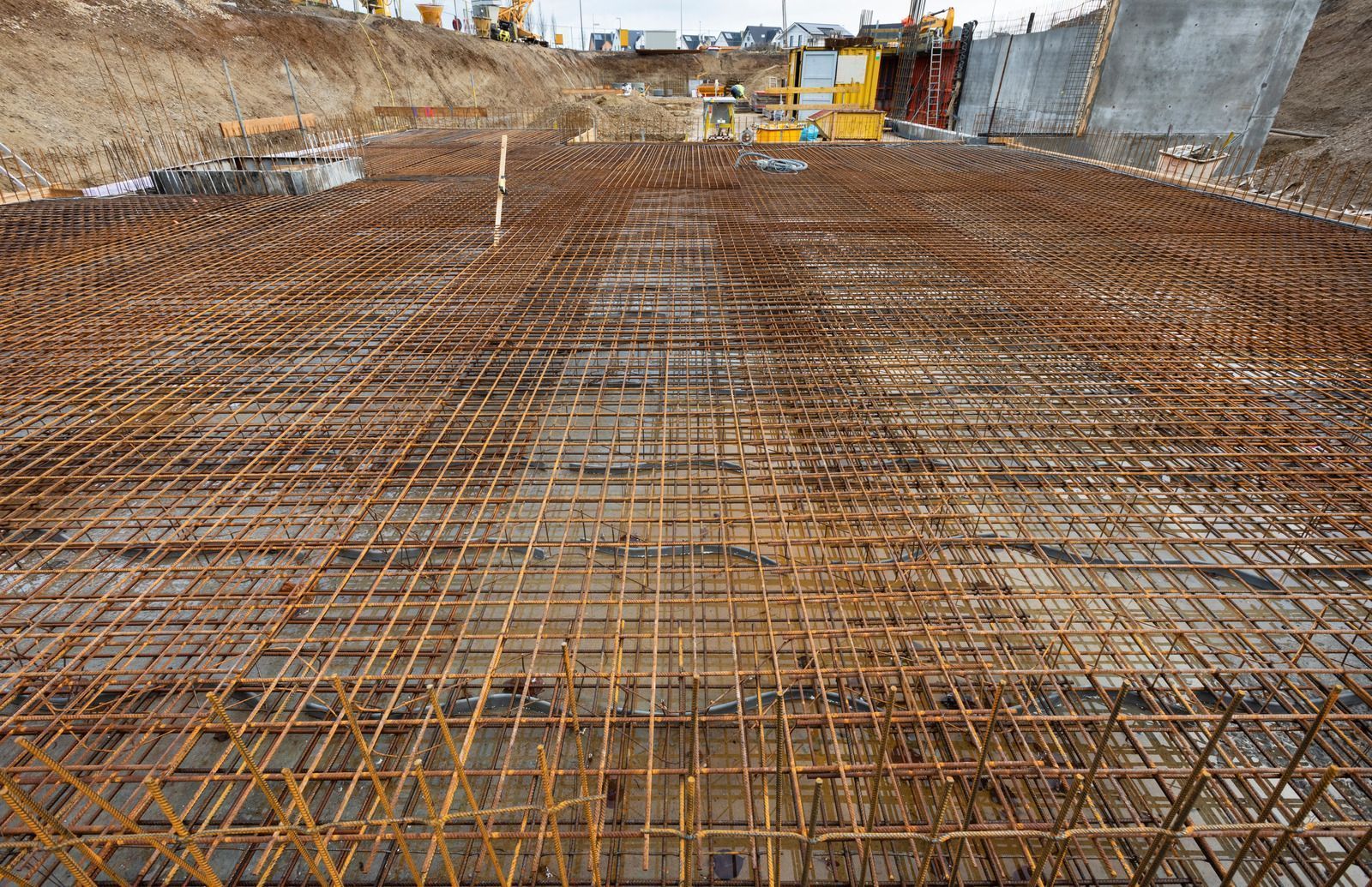 Reinforced steel grid for concrete foundation at a construction site.