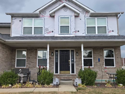 Two-story gray house with white trim, front walkway, and a small covered entryway