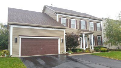 A large house with a garage and a driveway in front of it.