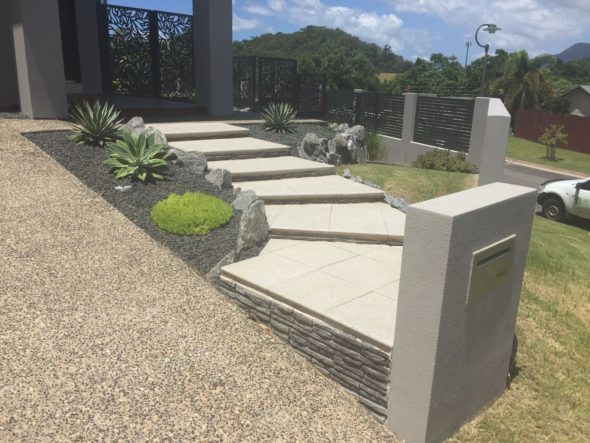 Front path created with concrete pavers, with feature letter-box and garden beds