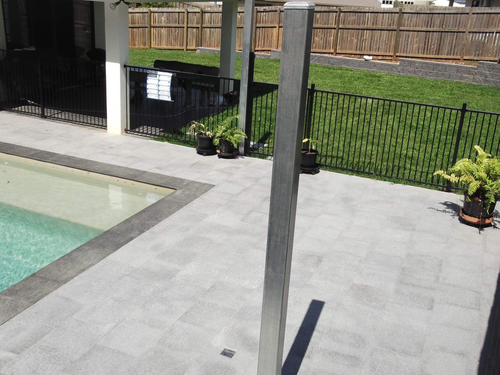 Natural stone paving with block retaining wall and new pool fencing