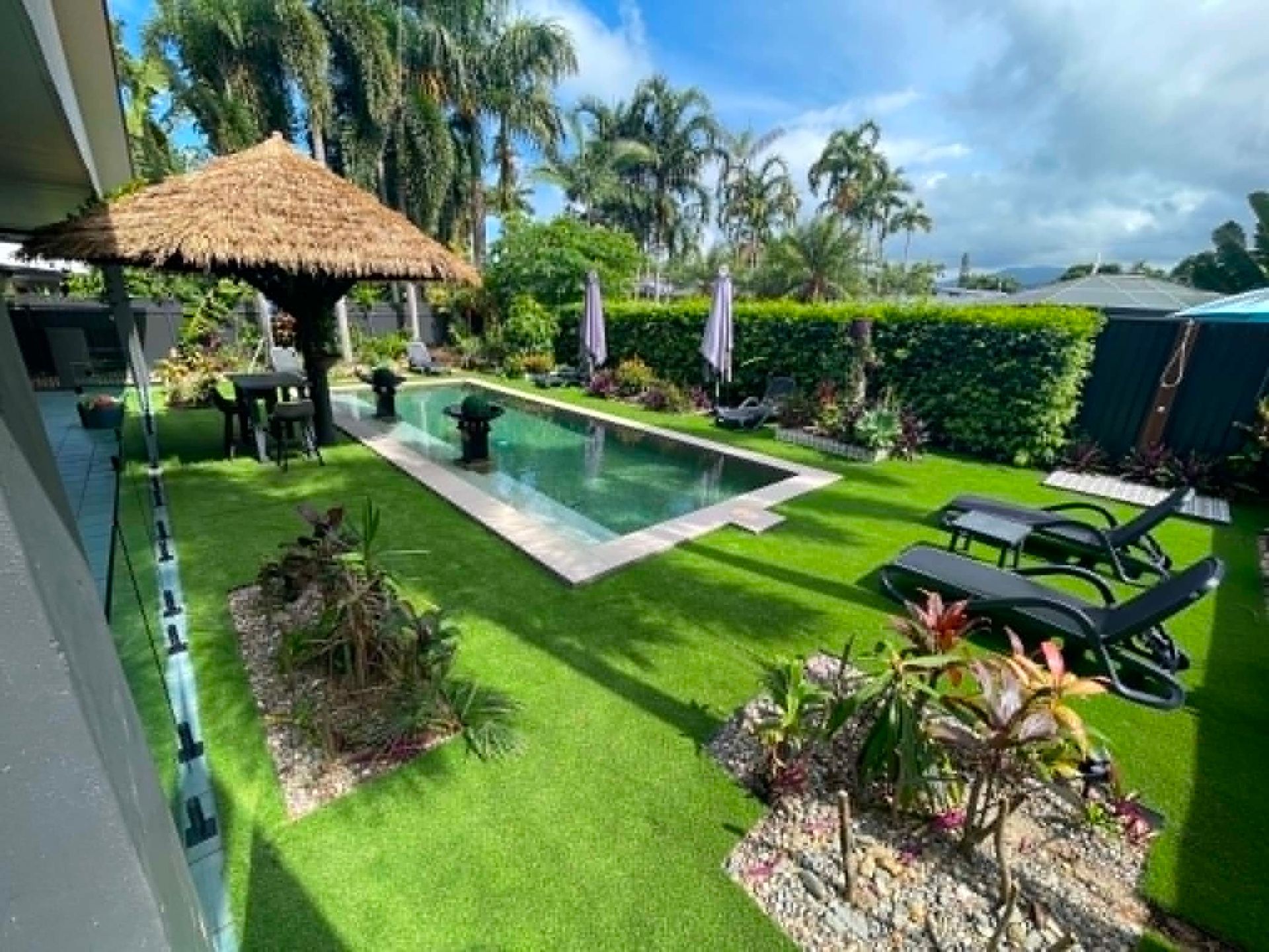 Tropical resort courtyard with new artificial lawn and planting