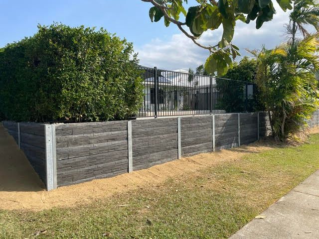 Concrete sleeper retaining wall system with standard pool fence installation