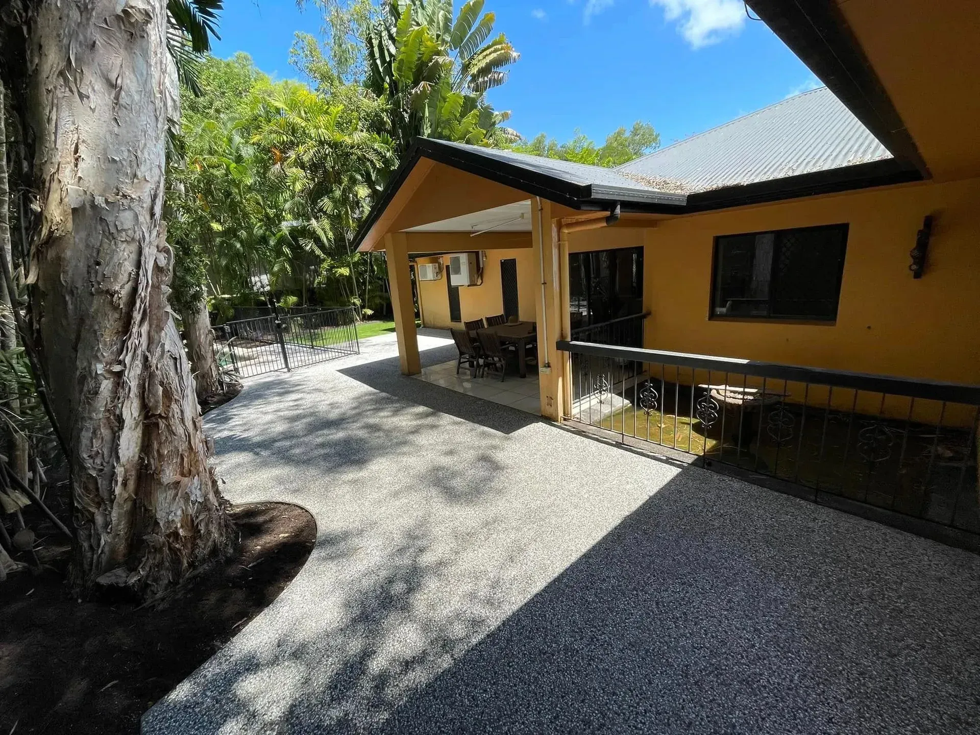 Exposed concrete driveway beside a Cairns home