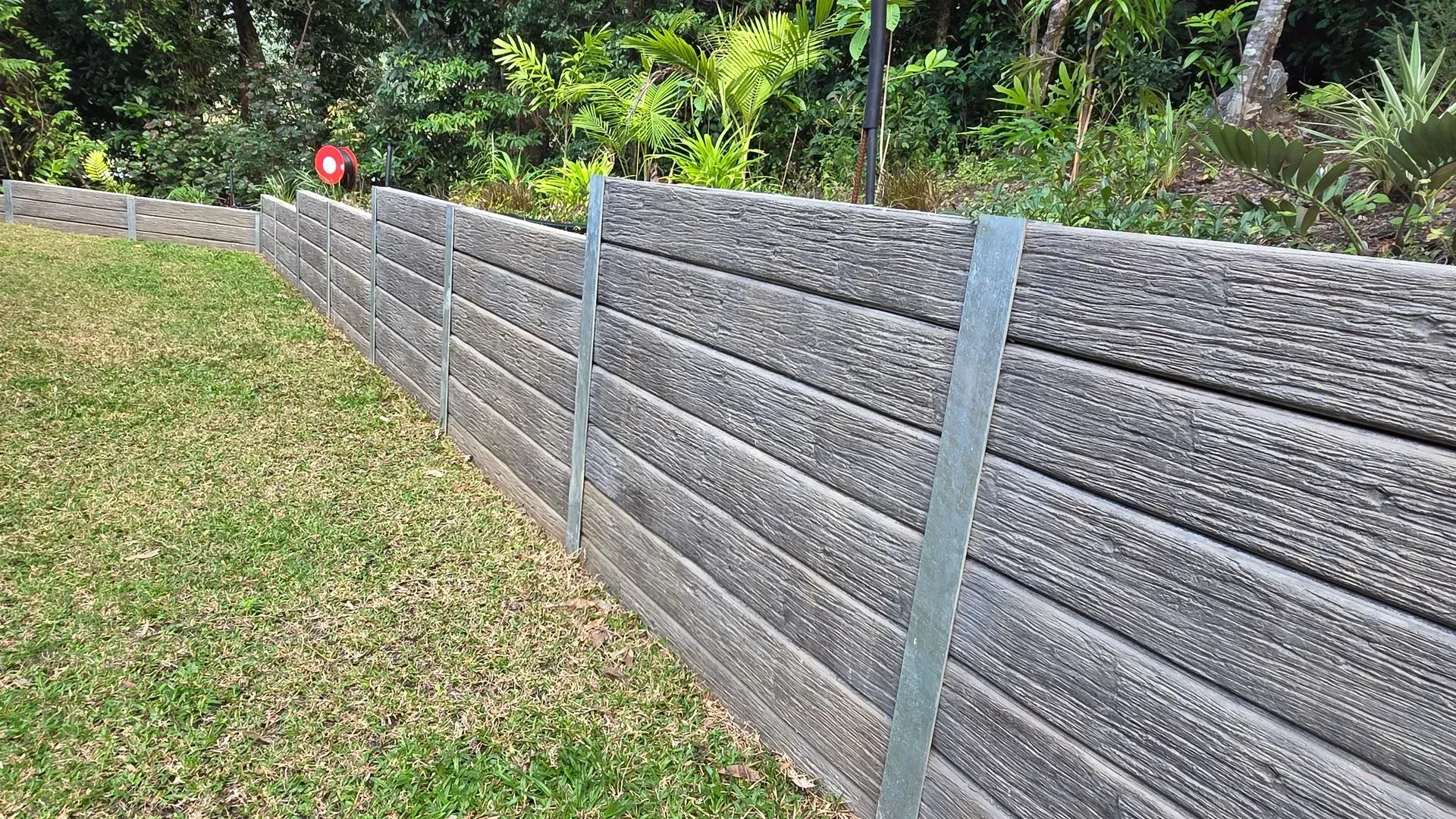 Concrete sleeper retaining wall with steel posts in a Cairns garden