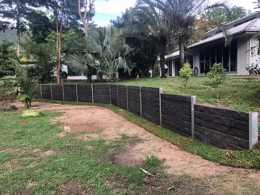 Curved sleeper retaining wall in a tropical residential garden in Cairns