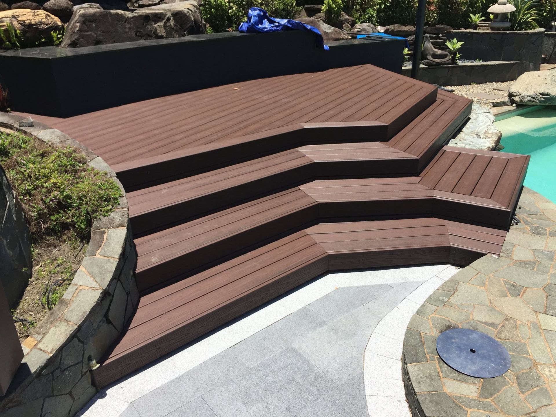 Concrete sleeper retaining wall system with water feature and Orchid garden installed