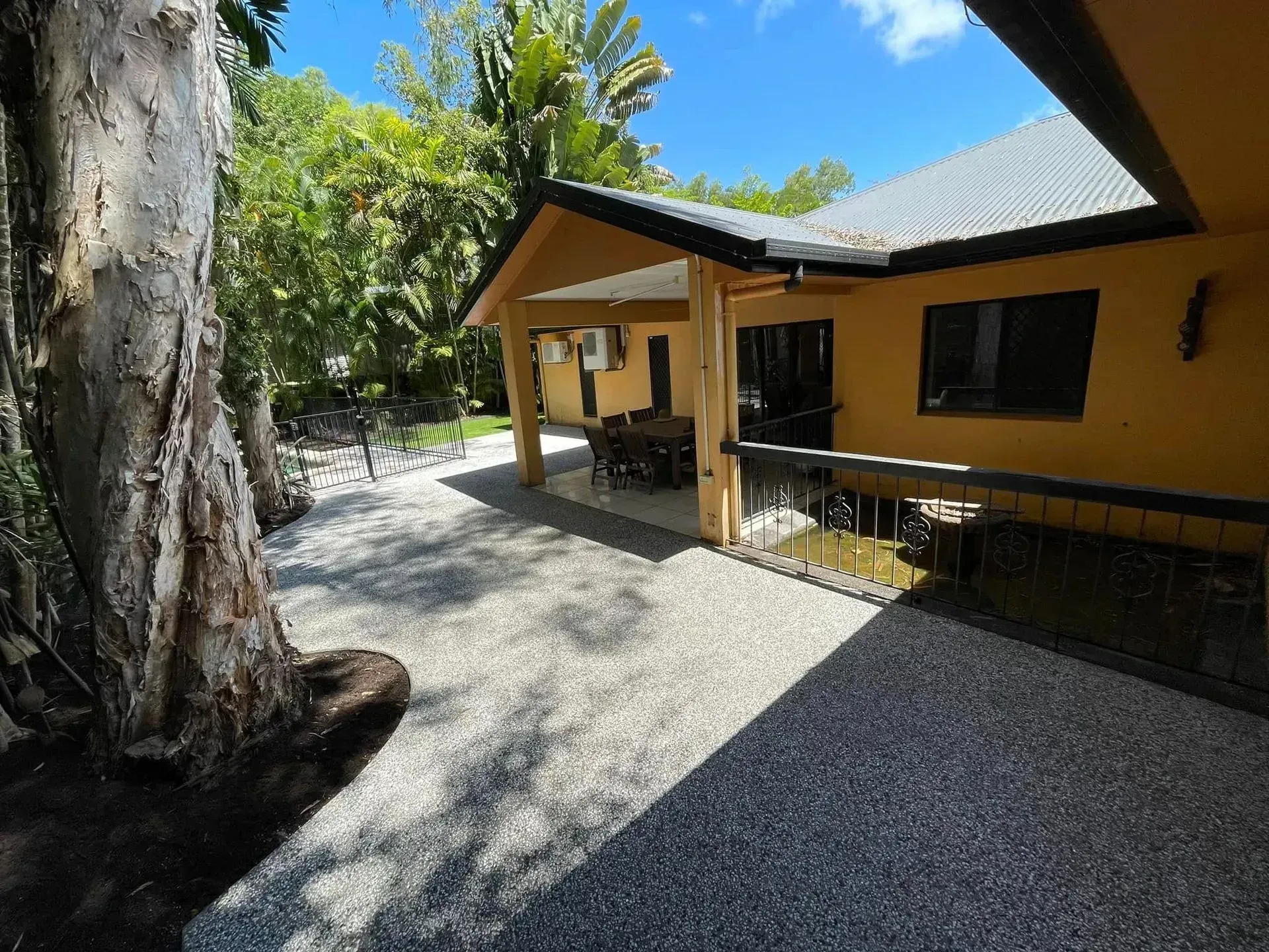 Exposed concrete driveway beside a Cairns home